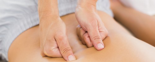 Physiotherapist doing back massage to her patient in medical office